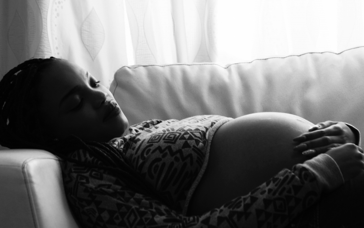 pregnant black woman lying down by Dexter Chatuluka via Unsplash
